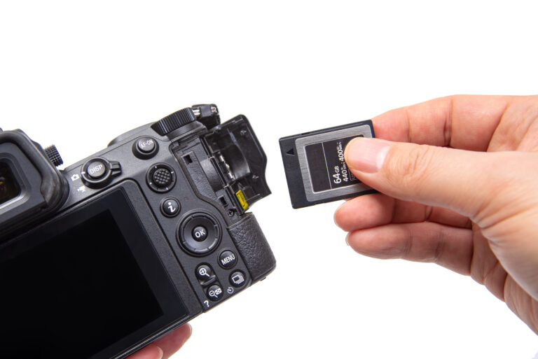 Hand inserting a CFexpress Memory card in to a digital camera